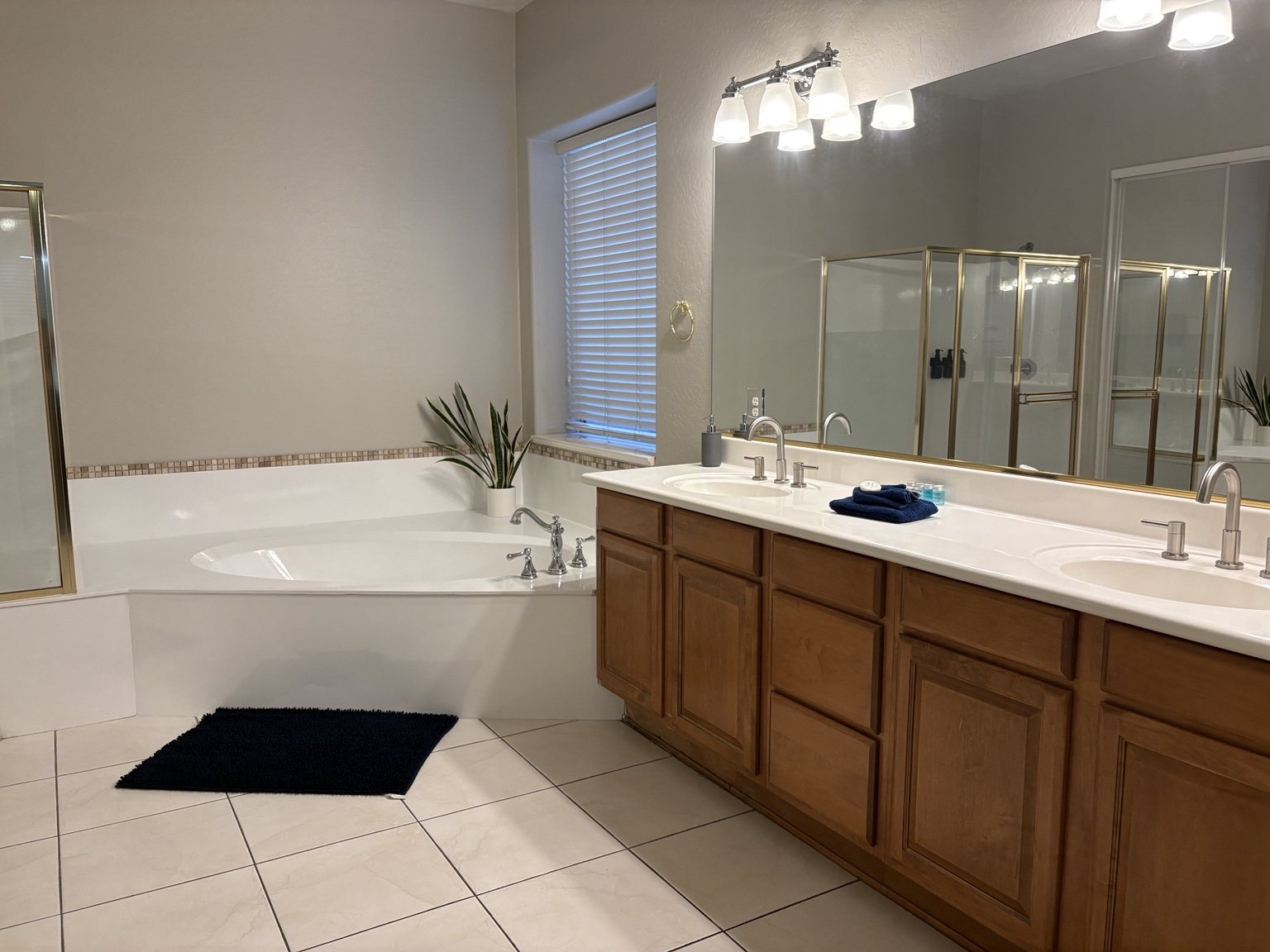Clean bathroom with bathtub, vanity and mirrors